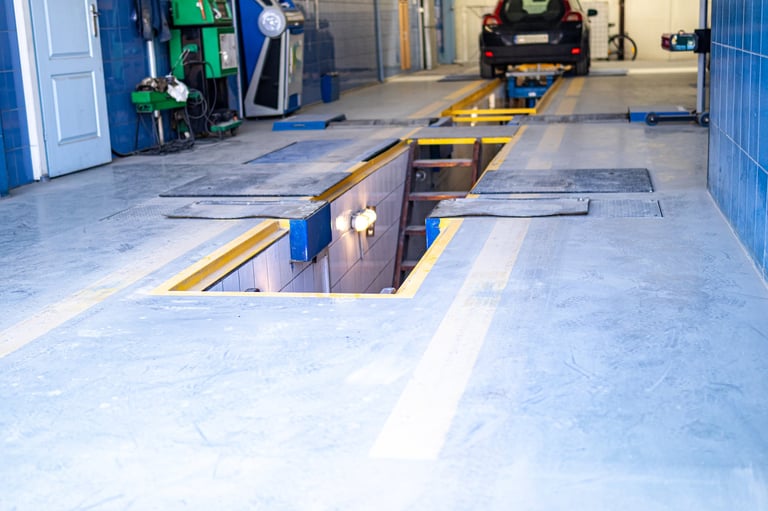 Interior of an automotive repair garage with vehicle inspection pit and maintenance platform